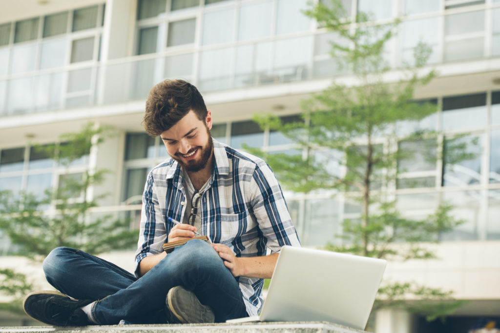 freelance-worker-full-creative-ideas-seated-lotus-pose-making-notes-outdoors